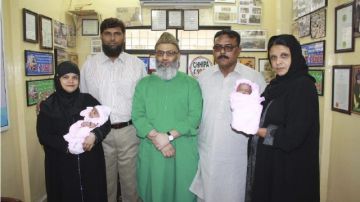 Los bebés en manos de sus nuevos padres que recibieron en  adopción en un programa de la televisión pakistaní.