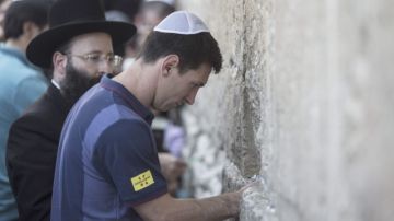 Lio Messi introduce el papelito con sus deseos en una de las grietas del  Muro de los Lamentos, ayer.