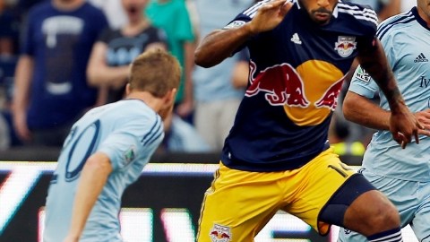 El francés  Thierry Henry (centro) de los Red Bulls maniobra entre dos hombres del  Sporting Kansas City.