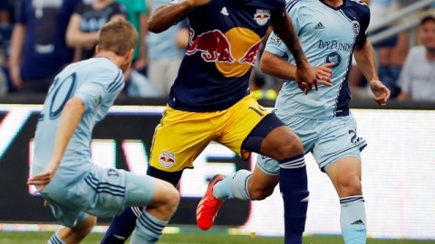El francés  Thierry Henry (centro) de los Red Bulls maniobra entre dos hombres del  Sporting Kansas City.