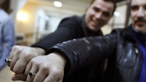 Rodrigo Borda (der.) y Sergio Miranda posan mostrando sus anillos luego de cumplir el trámite de incribirse para contraer matrimonio en el Registro Civil uruguayo.