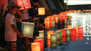 Un niño coloca una linterna de papel en el río Motoyasu en memoria de las víctimas de la bomba atómica.