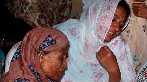Mujeres lloran sobre el cuerpo de uno de los niños muertos en el ataque durante un partido de fútbol en la ciudad de Karachi.