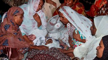 Mujeres lloran sobre el cuerpo de uno de los niños muertos en el ataque durante un partido de fútbol en la ciudad de Karachi.