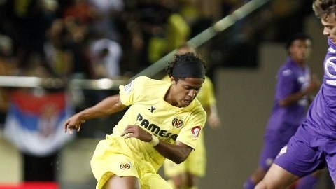 El jugador del Villarreal Giovani Dos Santos (izda), trata de hacerse con el balón ante el acoso del jugador del Fiorentina Ljajic