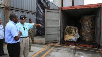 El ministro panameño de Seguridad, José Raúl Mulino (d), y el fiscal, Javier Caravallo (i) presentan un grupo de contenedores con piezas de aviones en el puerto de Manzanillo,  procedentes del barco de bandera norcoreana "Chong Chon Gang".