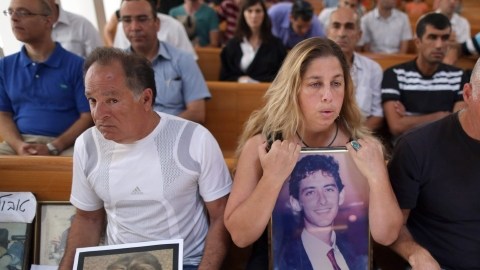 Gila Molcho (C), tiene la foto de su hermano Ian Feinberg, quien fue asesinado en 1993 por palestinos. Otras personas también mostraron fotos de familiares.