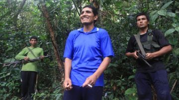 Marco Antonio Quispe Palomino, alias "Gabriel" (c), sonriendo acompañado de dos miembros de Sendero Luminoso durante un encuentro con periodistas en medio de la selva de la región Cusco,Perú.
