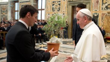 El papa Francisco recibe un regalo del astro Lionel Messi durante una audiencia privada del seleccionado albiceleste en el Vaticano.