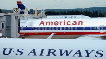 Un avión de American Airlines se ve entre dos  de US Airways en el aeropuerto  Nacional Ronald Reagan en Washington.