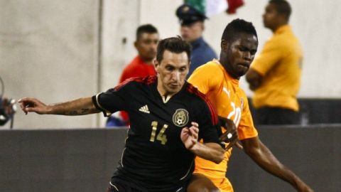Christian Giménez (i) de México en acción ante Abdul Razak (d) de Costa de Marfil
