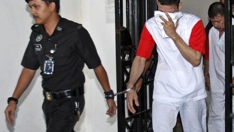 Policías malasios escoltan a José Regino Villareal (centro) y Luis Alfonso  González a su salida del  tribunal.