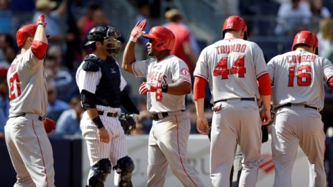 Mike Trout (27) saluda a Chris Nelson (8) luego que éste conecta grand slam ante los Yankees.