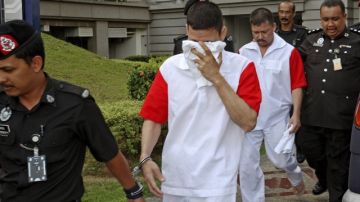 Policías escoltan a los mexicanos José Regino Villareal (centro) y Luis Alfonso González a su salida de una vista en el tribunal de apelaciones de Putrajaya, Malasia. Los tres hermanos aseguran que son inocentes.