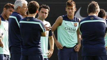 Los jugadores del F.C. Barcelona Xavi y Neymar, escuchan al nuevo técnico blaugrana.