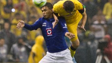 El colombiano Teófilo Gutiérrez, de Cruz Azul, disputa el balón con Paúl Aguilar, del América, en la final del fútbol mexicano.