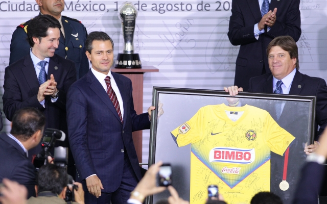 El presidente de México, Enrique Peña Nieto (izq), recibe una camiseta autografiada del América, de manos del entrenador Miguel 'Piojo' Herrera (d).