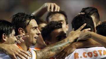 El defensa portugués del Valencia Ricardo Costa (d) es felicitado por sus compañeros tras marcar ante el Málaga, durante el partido de la primera jornada de Liga. EFE