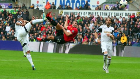 Esta jugada acrobática del holandés  Robin Van Persie (centro)    va a terminar en el primer gol del Manchester United, frente al   Swansea City.