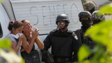 Familiares de un chofer de autobús urbano asesinado en noviembre de 2012, en Acapulco,  suplican a los policías federales y militares que les dejen ver el cuerpo, mientras se hacían las investigaciones.