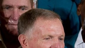 Bob Griese (i) y Don Shula (d), entregan un jersey autografiado a Obama.