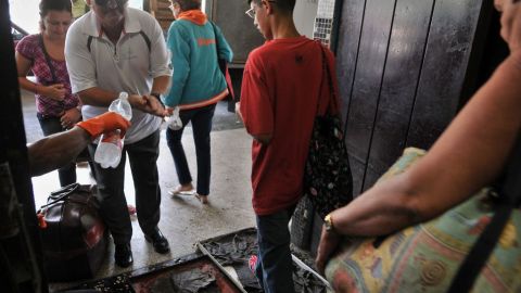 Varios cubanos pasan por un control de inspección en la Terminal de Ómnibus Nacional de la capital cubana.