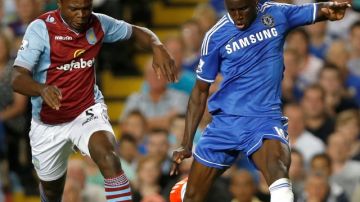 Chelsea's  Demba Ba, right, vies for the ball with Aston Villa's Jores Okore, left, during the English Premier League soccer match between Chelsea and Aston Villa at Stamford Bridge Stadium in London, Wednesday, Aug. 21, 2013. (AP Photo/Kirsty Wigglesworth)