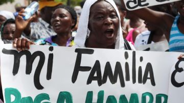 Mujeres de origen haitiano, viudas de trabajadores en cultivos de caña de azucar, participan en una marcha de protesta.