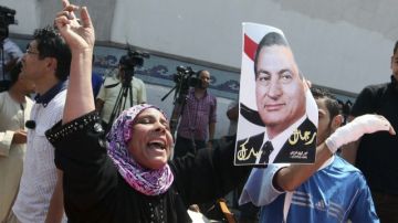 Una simpatizante del expresidente Hosni Mubarak celebra su puesta en libertad a la entrada de la cárcel de Tora, donde se encontraba recluido desde hace dos años.