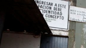 Una mujer que tiene un miembro de la familia dentro de la cárcel Palmasola, detrás, lee la historia de los disturbios de ayer en Santa Cruz, Bolivia.