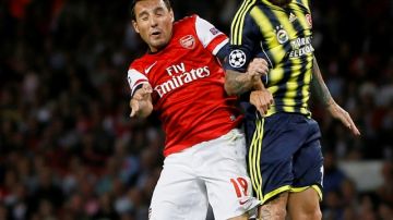 Santi Cazorla (izq.), del Arsenal, disputa un balón aéreo  con Raúl Meireles, del Fenerbahce, en el partido disputado ayer en Londres.