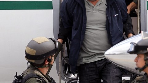 Miembros de la Policía  custodiando a Diego Pérez Henao (c), alias "Diego Rastrojo", considerado el jefe de la banda de origen paramilitar 'Los Rastrojos'.