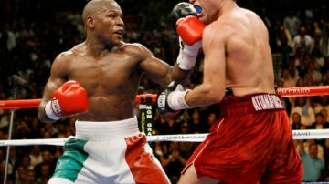 Floyd Mayweather Jr. golpea a Oscar de la Hoya en la pelea en que lo venció por decisión dividida al mexicano-estadounidense en mayo del 2007.