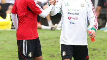 Javier "Chicharito" Hernández (i) estrecha la mano de Christian Giménez durante una práctica de la selección de  México.