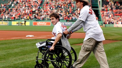 Jeff Bauman, sobreviviente de los atentados en Boston, es trasladado por Carlos Arredondo, el hombre que lo auxilió, como parte de una ceremonia en Fenway Park, en mayo de este año.