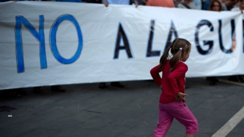 Una niña corre junto a una pancarta durante una protesta en España contra la intervención militar en Siria.