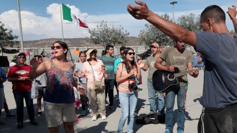 Grupos religiosos comparten con los  migrantes deportados en el refugio temporal conocido como 'El Mapa' en Tijuana.