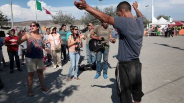 Grupos religiosos comparten con los  migrantes deportados en el refugio temporal conocido como 'El Mapa' en Tijuana.
