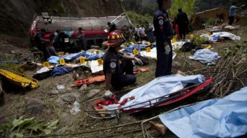 Bomberos y rescatistas trabajan en la zona de un autobús accidentado  donde al menos 43 personas murieron.