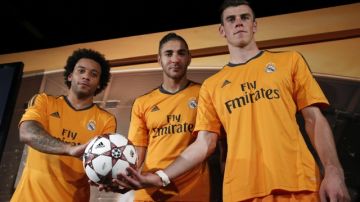 Marcelo Vieira (izq.),  Karim Benzema y Gareth Bale  presentan el uniforme del Madrid para la  Champions.