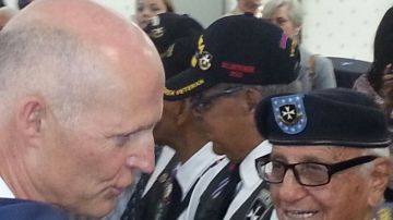 El gobernador de Florida, Rick Scott, habla con el Borinqueneer Andrés Vergara, de 91 años, veterano de la II Guerra Mundial. Vergara fue uno de 50 soldados Borinqueneers a quien el gobernador le otorgó la Medalla de Servicio de Florida.