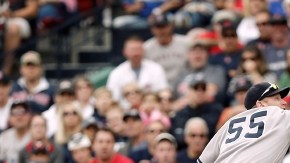 Lyle Overbay (55) no alcanza a atrapar la pelota lanzada por el antesalista yankee, Mark Reynolds y Mike Napoli  (12), de los Medias Rojas, se enbasa en primera.