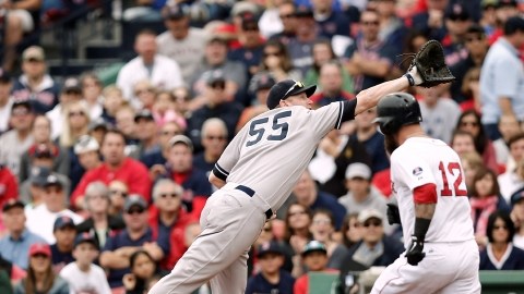 Lyle Overbay (55) no alcanza a atrapar la pelota lanzada por el antesalista yankee, Mark Reynolds y Mike Napoli  (12), de los Medias Rojas, se enbasa en primera.