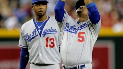 Juan Uribe (5) captura un elevado custodiado muy de cerca por Hanley Ramírez en acción del quinto inning del juego de ayer.