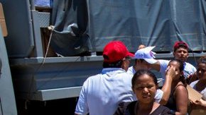 Damnificados por las lluvias cargan con víveres en el "Boulevard de Las Naciones", en Acapulco.