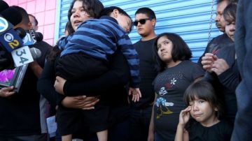Gabriela Sánchez (centro), hija mayor de la víctima,   sostiene a su hermano menor,  Isaac, durante la rueda de prensa para encontrar al asesino.