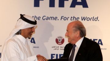 El presidente de FIFA, Sepp Blatter (der.) saluda al dirigente de Qatar,  Bin Ahmed al-Thani, tras ganar la nominación al Mundial del 2022.