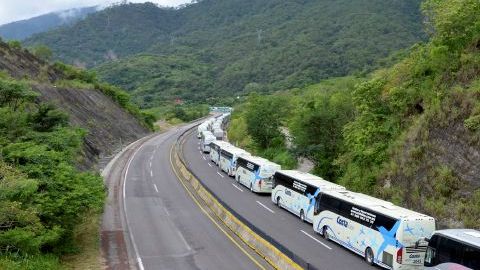 Autobuses se dirigen a recoger turistas a la ciudad de Acapulco por la recién abierta vía que comunica con la Ciudad de México.