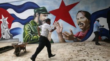 Un hombre cruza frente a un mural con las imágenes del líder cubano Fidel Castro y del presidente nicaragüense, Daniel Ortega, en la Plaza Cuba, en Managua, Nicaragua.