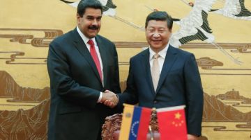 El presidente chino, Xi Jinping (D) estrecha la mano del presidente Nicolás Maduro    durante la ceremonia de firma en el Gran Palacio del Pueblo en Beijing.